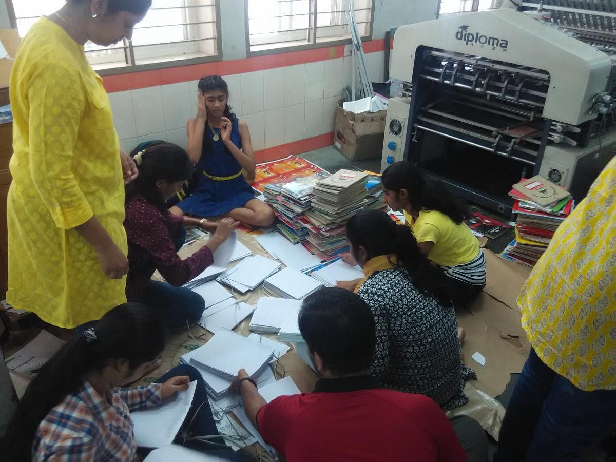 The volunteers of Youth For Seva separate blank pages from notebooks collected from students. NOT DH PHOTO
