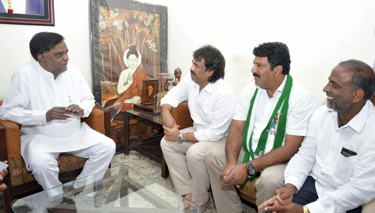 JD(S) state youth wing president Madhu Bangarappa interacts with state BJP vice president V Srinivas Prasad at the latter's residence in Mysuru on Tuesday. JD(S) Assembly poll candidates Azeez Abdul and K V Mallesh are seen. DH Photo
