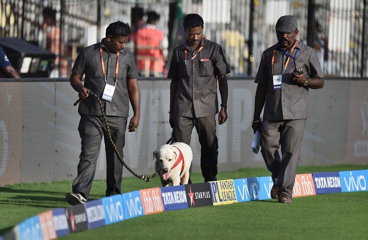 Police personnel with sniffer dog inspect the ground during the IPL match between Chennai Super Kings (CSK) and Kolkata Knight Riders (KKR) at MAC Stadium in Chennai on Tuesday. PTI Photo