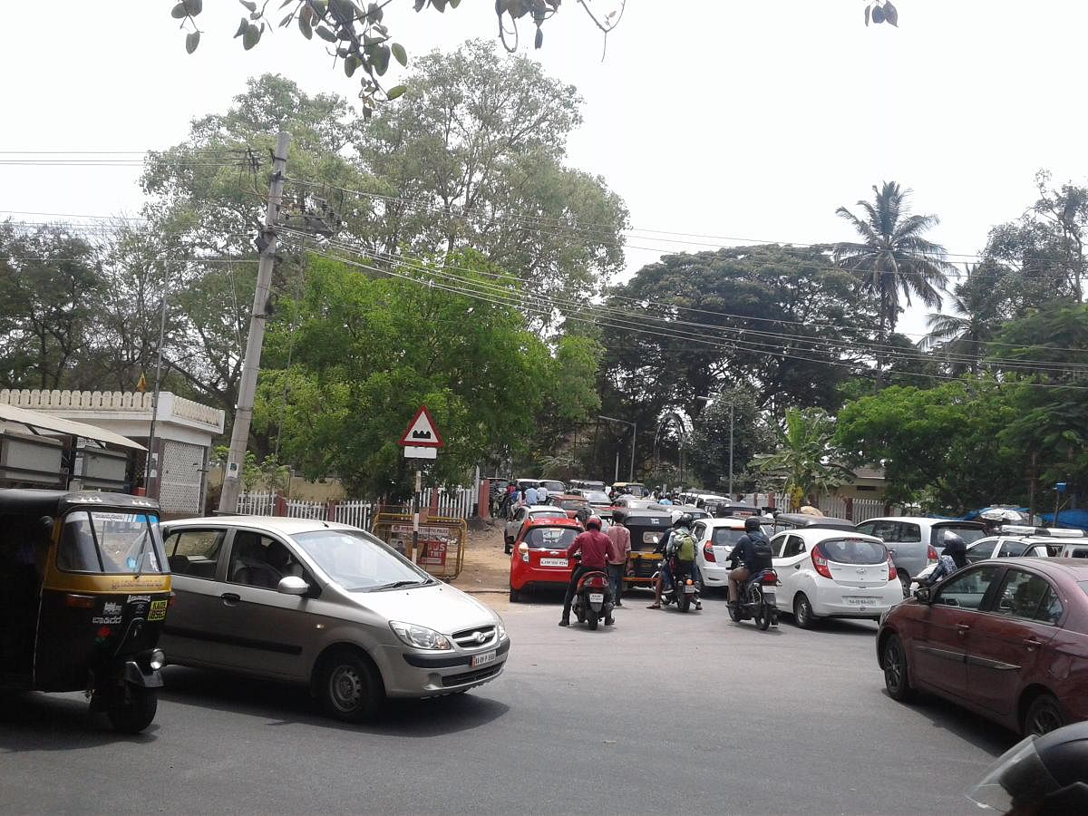 Vehicles wait on the Kukkarahalli Lake side when the railway level crossing on Radhakrishnan Avenue is closed, in Mysuru. dh photo