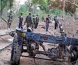Para-military soldiers inspect the site where Maoist rebels blew up an army truck, in Bijapur district of Chattisgarh on Saturday. PTI
