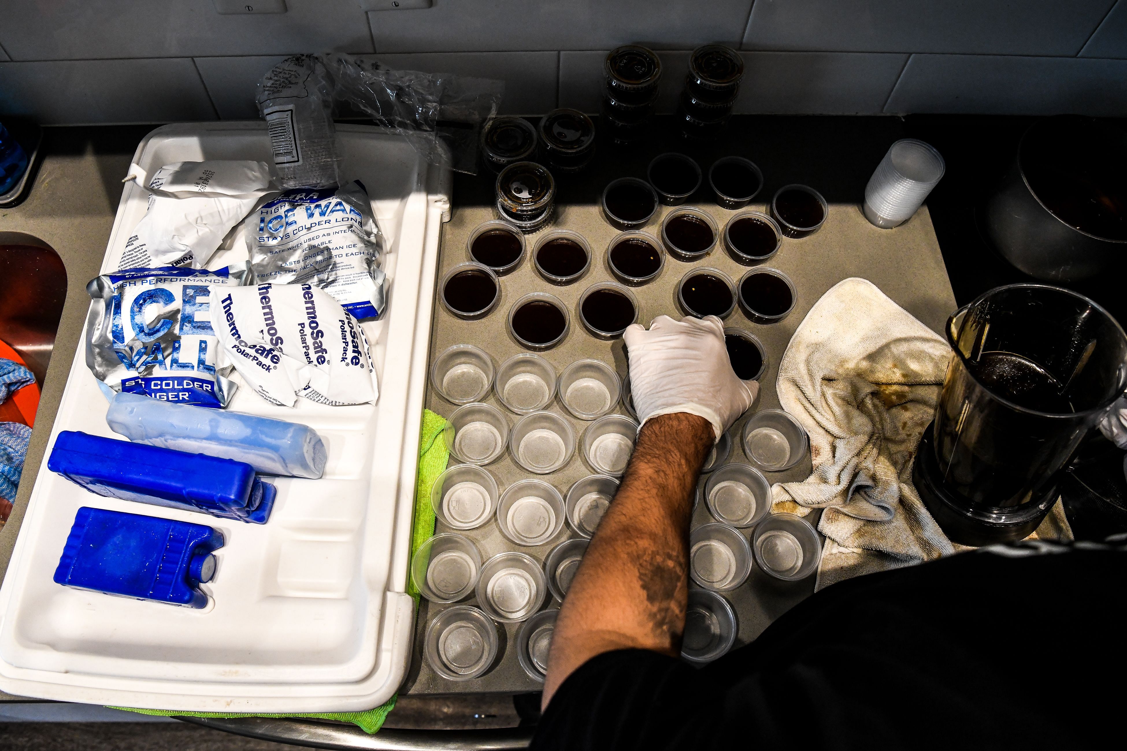 Rafael Delgado (29), who used to work as an Uber driver and recently found himself unemployed, prepares containers of dipping sauce to serve with homemade tequenos, a popular Venezuelan snack, inside his home in Miami. (AFP)