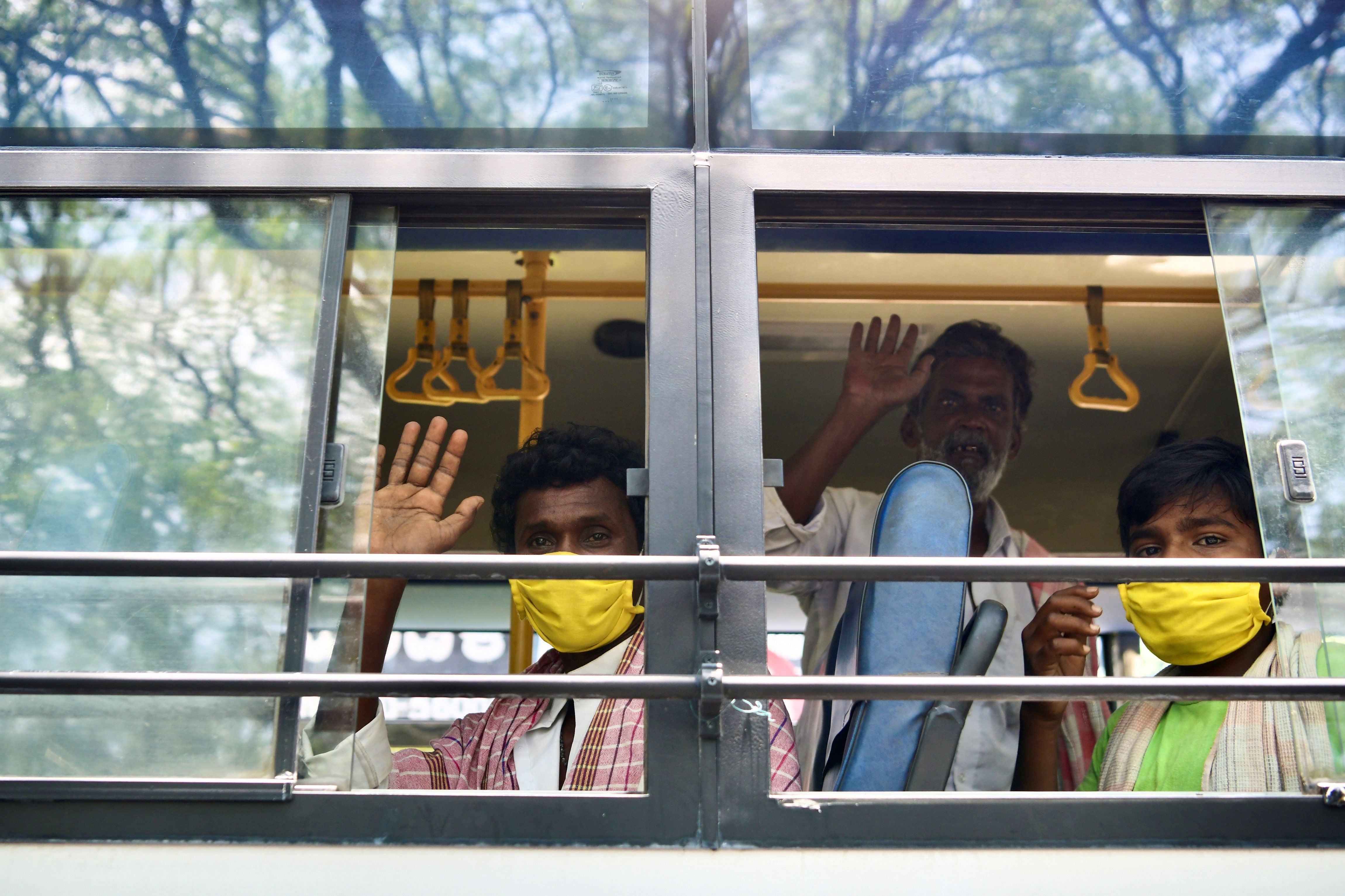Migrant workers wave from inside a bus before leaving for their hometowns during a government-imposed nationwide lockdown as a preventive measure against the spread of COVID-19 coronavirus in Bangalore. (AFP)