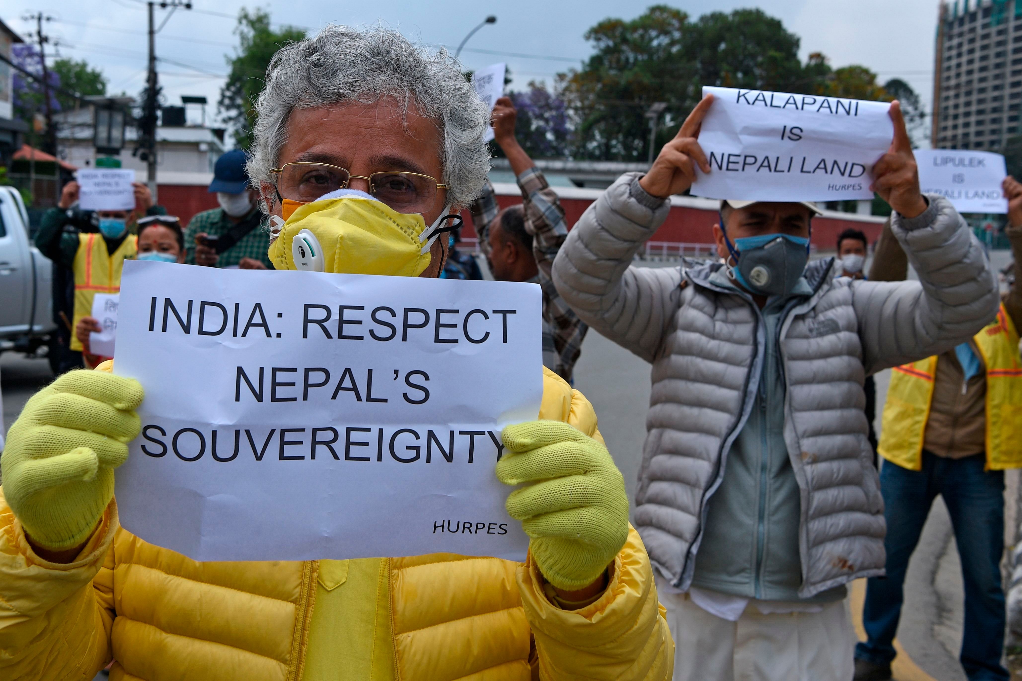 Human rights activists hold placards during a protest against India's newly inaugurated link road to the Chinese border, near Indian embassy in Kathmandu on May 12, 2020. - Nepal protested India's inauguration of a new road to China that passes through territory claimed by Kathmandu on May 9, with police detaining dozens of demonstrators. (Photo by AFP)