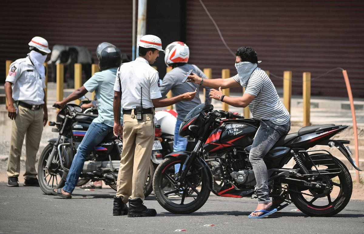 Police personnel stop commuters after lockdown in the wake of deadly coronavirus, in Vijayawada, Tuesday, March 24, 2020. (PTI Photo)