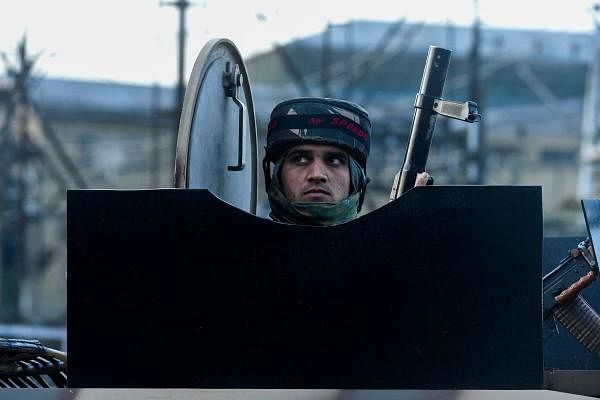 An Indian paramilitary soldier mans his position standing on an armoured vehicle near a site of a gun battle between suspected militants and government forces in downtown Srinagar on May 19, 2020. (Credit: AFP Photo)