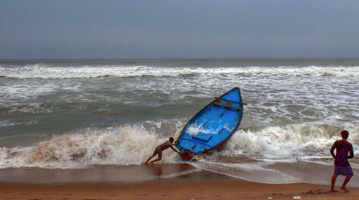 Fishermen try to control their boat amidst rough sea waters ahead of the landfall of Cyclone Amphan at Puri beach, Tuesday, May 19, 2020. (PTI Photo)