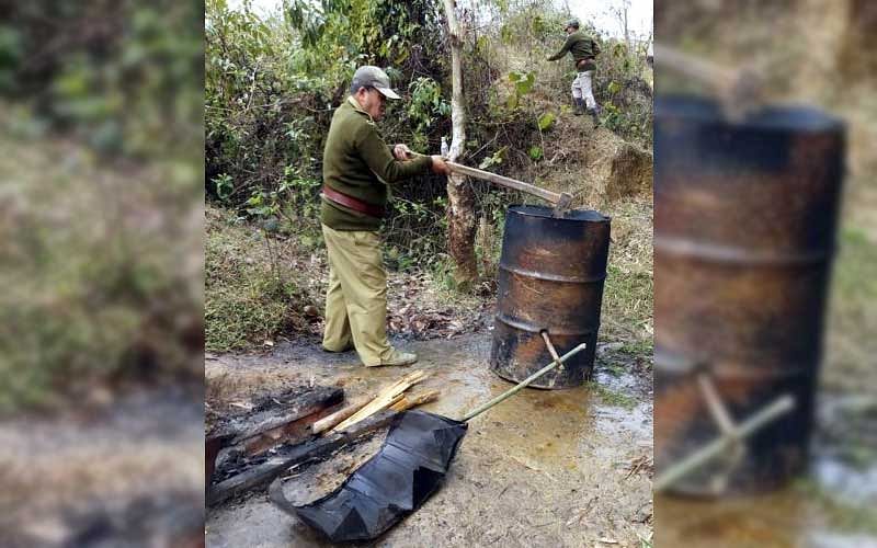 Officials of Assam's Excise Department and District Administration destroying units, making illicit liquors in Golaghat and other areas of the state. More than 15,000 litres of liquor has been destroyed till now. (PTI Photo)