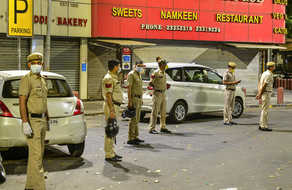 Police officials seal the Bengali market area after a case of coronavirus was reported, during the lockdown, New Delhi. (PTI Photo/Kamal Kishore)