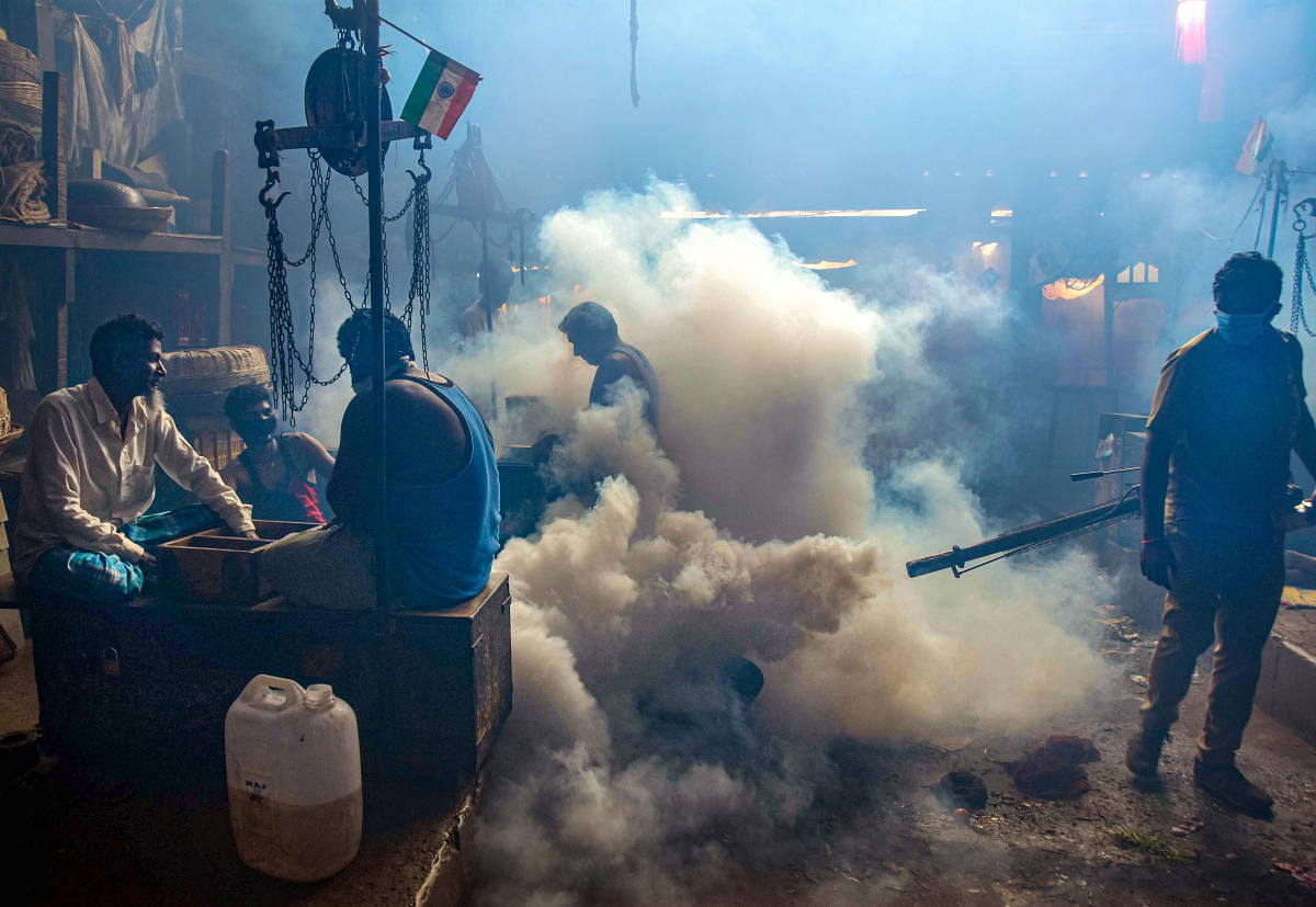 Brihanmumbai Municipal Corporation (BMC) worker fumigates Byculla market area as a precautionary measure against the spread of coronavirus (PTI Photo)