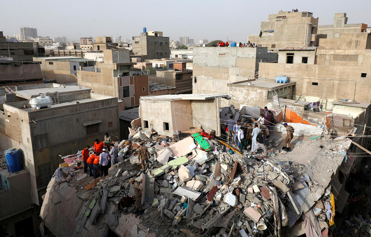 Rescue workers search for survivors from the rubble of a residential building which collapsed in Karachi. (Reuters photo)