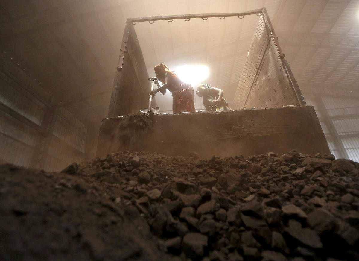  Workers unload coal from supply truck at yard on outskirts of the western Indian city of Ahmedabad. Credit: PTI Photo