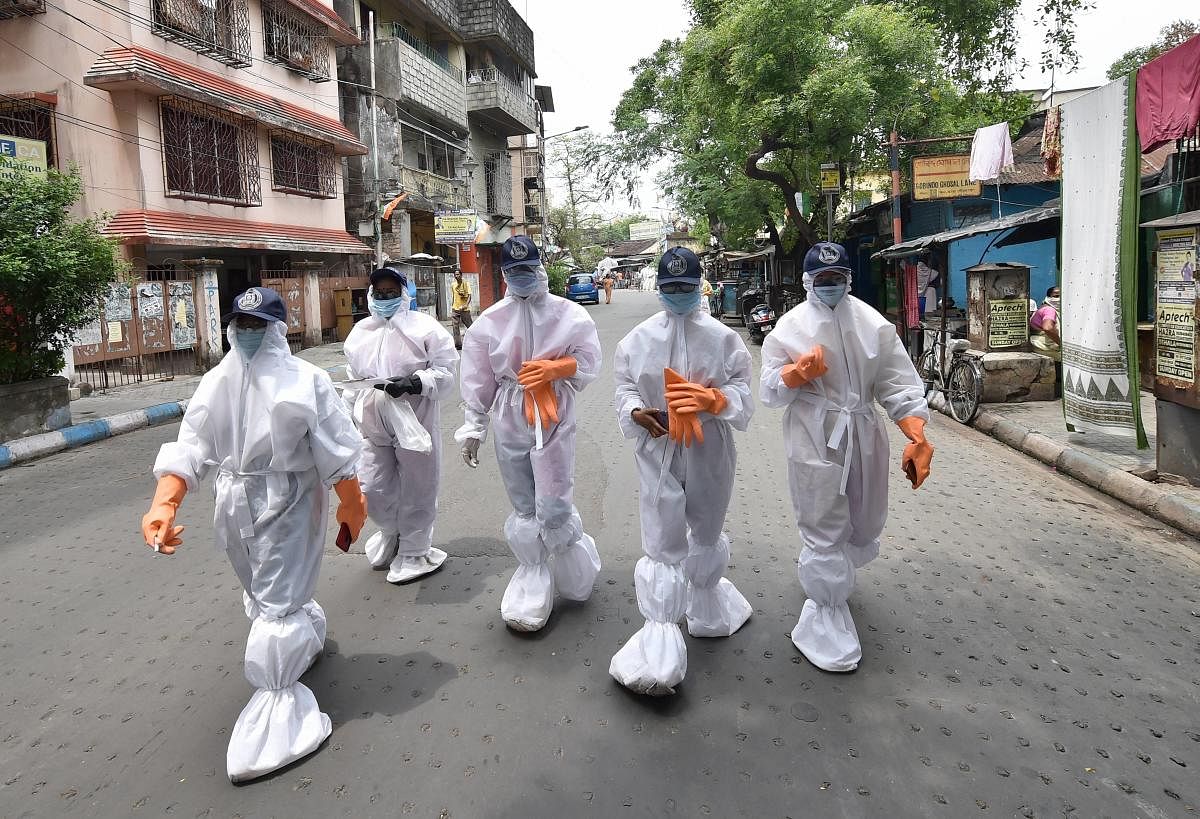  Health workers wearing protective suits walk in a locality during their door-to-door surveillance to detect COVID-19 cases, in Kolkata (PTI Photo)