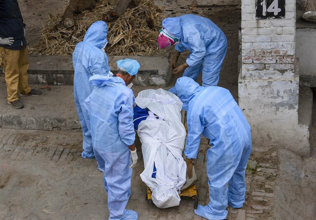 Medics prepare to cremate a COVID-19 patient during the nationwide lockdown to curb the spread of coronavirus, in Jalandhar, Thursday, April 9, 2020. (PTI Photo)