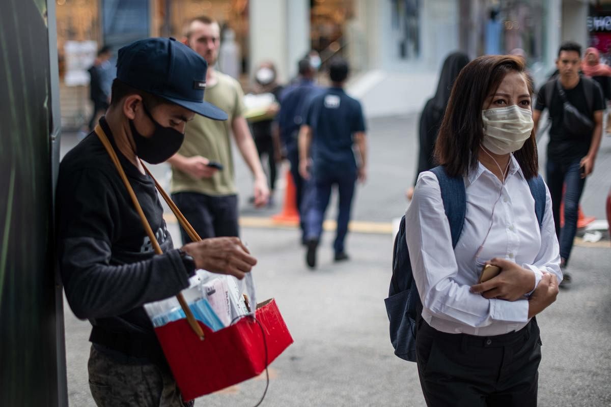 A man (L) sells protective facemasks, amid fears over the spread of the COVID-19 coronavirus (AFP Photo)