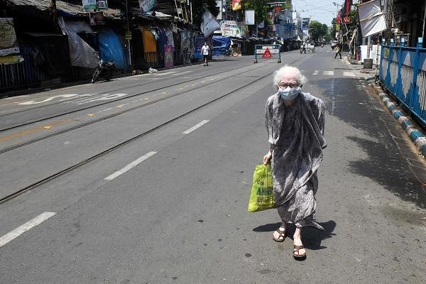 Elderly woman walks back home after collecting essentials during nationwide coronavirus lockdown, in Kolkata. (Credit: AFP Photo)