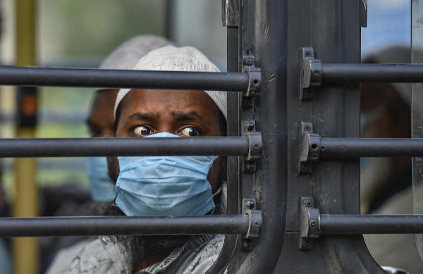 People wearing masks leave for hospital in a bus from Nizamuddin area, after several people showed symptoms of coronavirus following taking part in a religious gathering a few days ago, during the nationwide lockdown, in New Delhi, Monday, March 30, 2020. (PTI Photo/Ravi Choudhary)