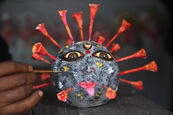 A artisan gives finishing touches to a COVID-19 coronavirus model during a government-imposed nationwide lockdown as a preventive measure against the COVID-19 coronavirus, in Kolkata on April 23, 2020. (Credit: AFP Photo)