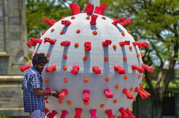 An artist gives a final touch to a model based on coronavirus placed alongside a road to raise awareness, during a government-imposed nationwide lockdown, in Chennai, Wednesday, April 29, 2020. (PTI Photo/R Senthil Kumar)