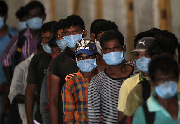 Indian fishermen, who said they were refused entry at two ports after a nationwide lockdown was imposed to fight the coronavirus disease (COVID-19), wait to get their health checkup after they disembarked from their boats after travelling in the Arabian Sea to reach to their home state Maharashtra from the western state of Gujarat, in Dahanu in Palghar district in Maharashtra, India, April 17, 2020. (Reuters Photo)