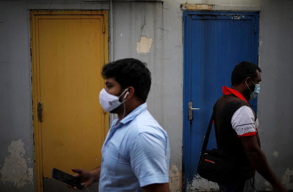 Migrant workers wearing face masks walk through Little India district as the spread of COVID-19 continues in Singapore. (Credit: Reuters Photo)