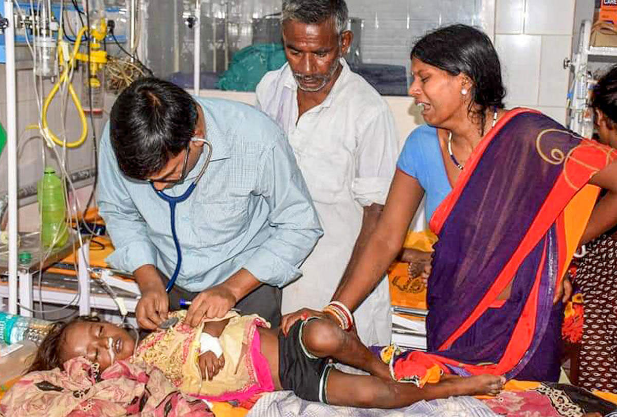 A doctor treats a child showing symptoms of Acute Encephalitis Syndrome (AES) at a hospital in Muzaffarpur, Tuesday, June 11, 2019. At least a dozen children in the city have died due to the disease while many others are being treated in several hospitals. (PTI Photo)