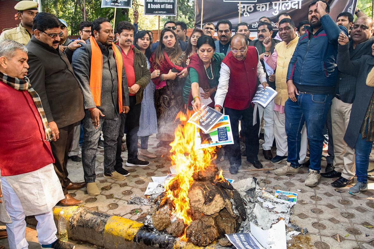 BJP leader Vijay Goel and others burn copies of Aam Aadmi Party (AAP) manifesto, ahead of State Assembly polls, in New Delhi. (PTI Photo)