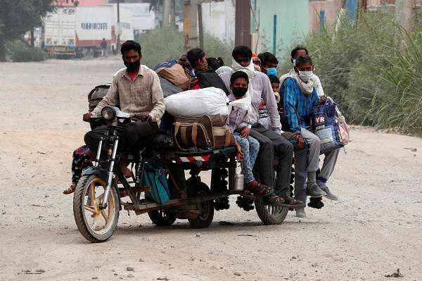 Migrant workers ride on a vehicle as they return to their village, during an extended nationwide lockdown to slow the spread of the coronavirus disease (COVID-19), in Ghaziabad, in the outskirts of New Delhi, India, May 13, 2020. (Credit: Reuters/Adnan Abidi)