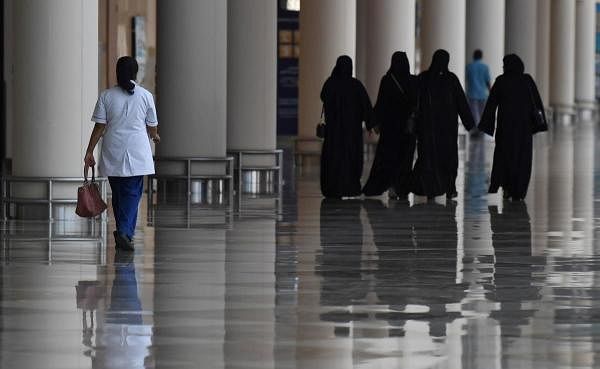 Emirati women walk in a nearly deserted shopping centre during the novel coronavirus pandemic crisis in the Gulf Emirate of Dubai, on April 19, 2020. (AFP Photo)