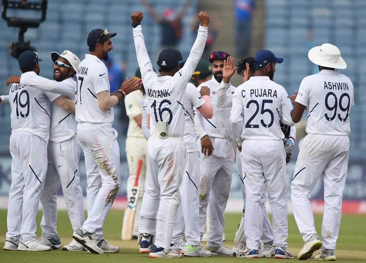 Indian cricketers celebrate on the fourth day of play after winning the second Test cricket match against South Africa at the Maharashtra Cricket Association Stadium in Pune on October 13, 2019. (Photo by PUNIT PARANJPE / AFP) 