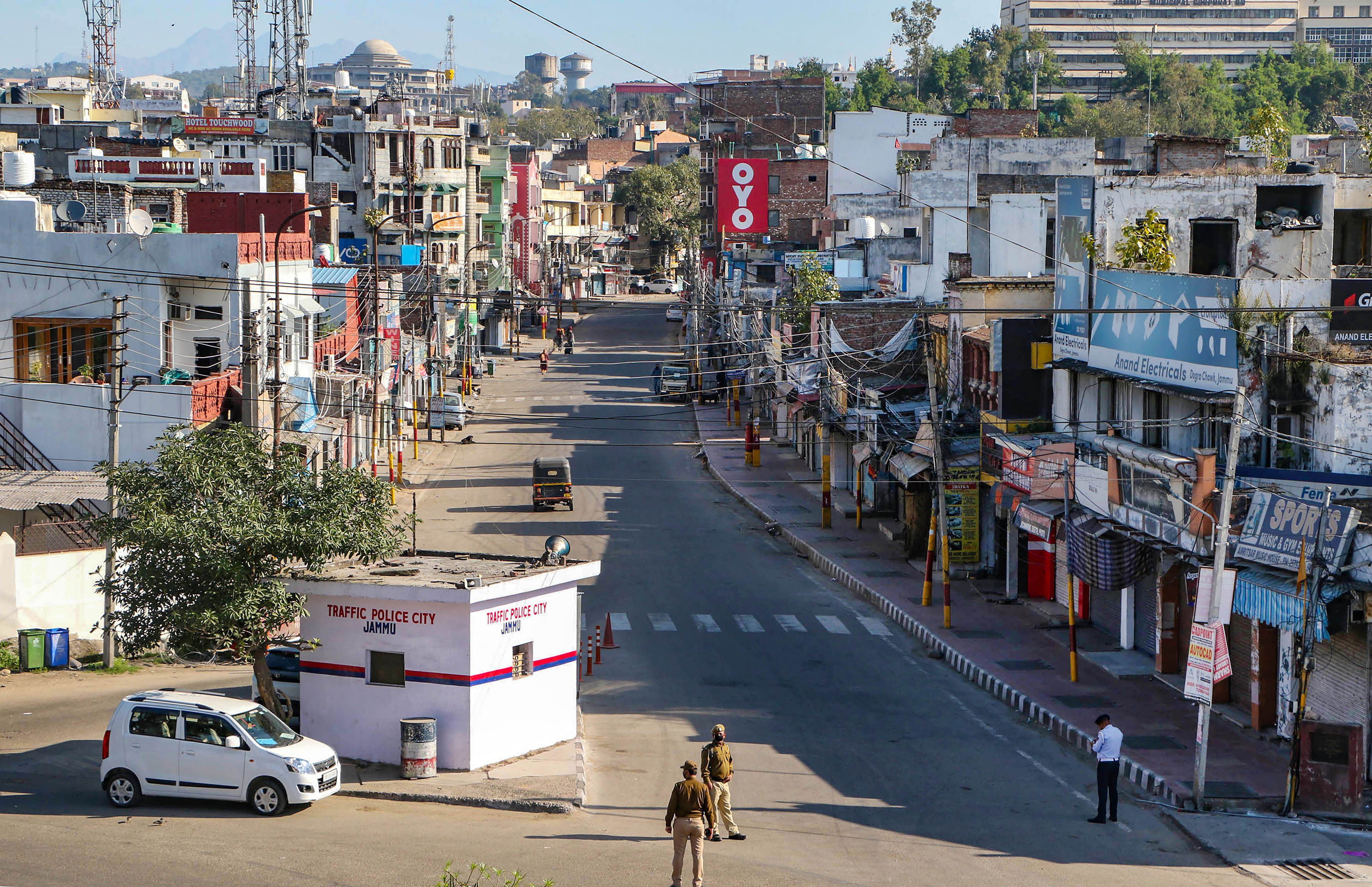 Security personnel wearing protective face mask stand guard on a deserted city street during 'Janata curfew' in the wake of coronavirus pandemic, in Jammu, Sunday, March 22, 2020. (PTI Photo)