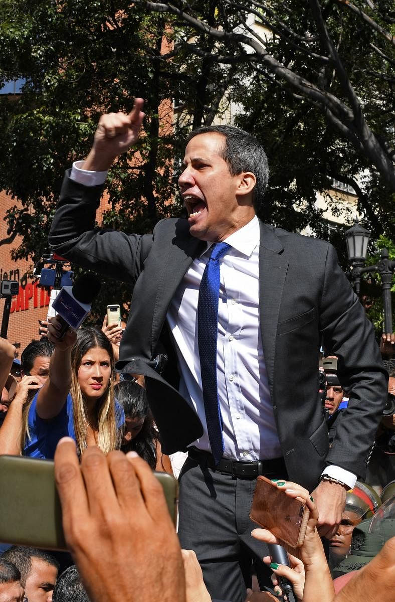 Venezuelan opposition leader and self-proclaimed acting president Juan Guaido shouts surrounded by journalists on his way to the National Assembly, in Caracas, on January 7, 2020. AFP