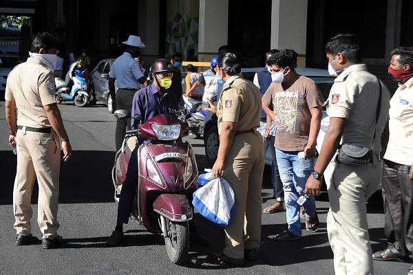 As people continue to come out of their houses, cops at Mysore Sandal soap factory, Bengaluru stop and check for their passes and enquire reasons for stepping out. DH Photo/ Pushkar V