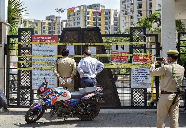 Police personnel outside the sealed KDP Grand Savanna society, marked as a COVID-19 hotspot, during the nationwide lockdown to curb the spread of coronavirus, at Rajnagar Extension in Ghaziabad. (Credit: PTI Photo)