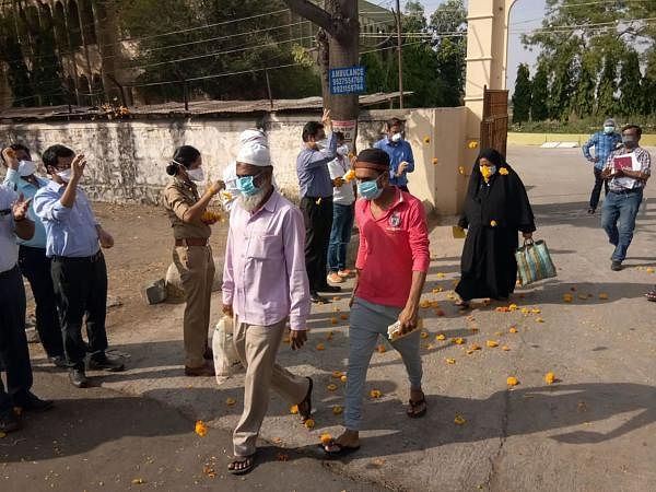 Medical staff and police personnel shower flower petals on COVID-19 patients as they leave the hospital after recovering, during the nationwide lockdown, at Malegaon in Nashik, Monday, April 27, 2020. (PTI Photo)