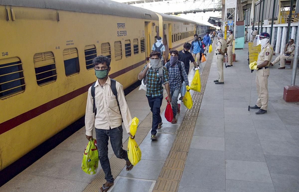 Migrants stand in a queue before boarding 'Shramik Special' train (PTI Photo)