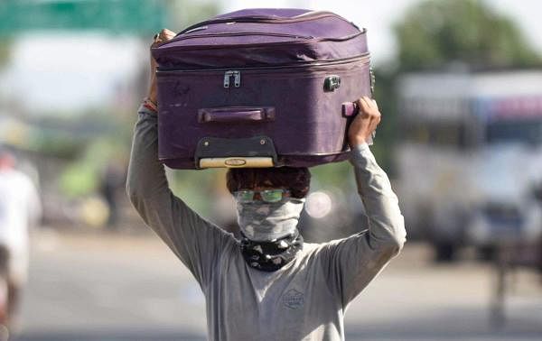 A migrant walks towards his native village in Uttar Pradesh, during a government-imposed nationwide lockdown as a preventive measure against coronavirus, at Rewa district, Sunday, May 17, 2020. (PTI Photo)
