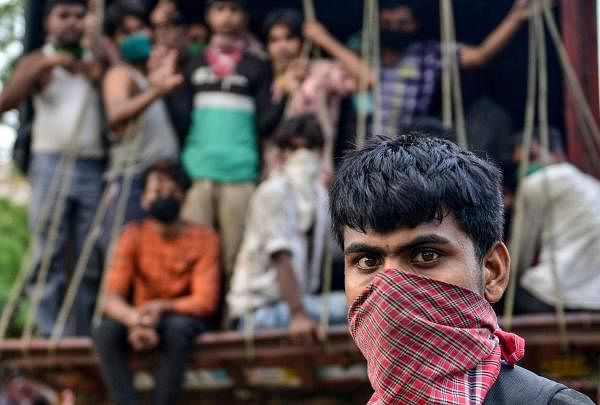 Migrant workers who arrived from Maharashtra state travel on a mini truck to go back to their hometowns, after the government eased a nationwide lockdown imposed as a preventive measure against the COVID-19 coronavirus, in Allahabad on May 15, 2020. (Credit: AFP Photo/Sanjay Kanojia)