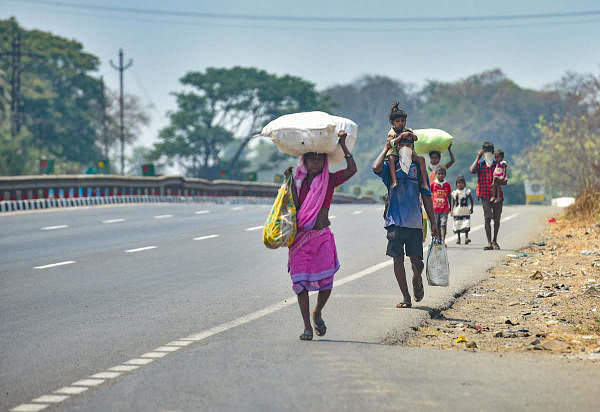 Migrants from Dahanu walk along the Mumbai-Ahmedabad highway, following the coronavirus lockdown, in Palghar, Monday, March 30, 2020. (PTI Photo/Mitesh Bhuvad) 