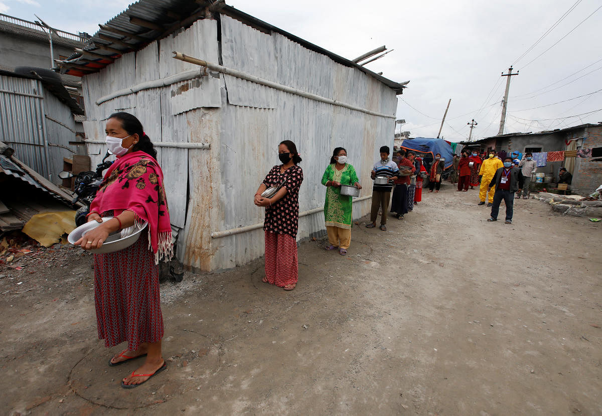 People maintain social distance as they wait for food distributed by the volunteers during the thirty-six days of the lockdown imposed by the government amid concerns about the spread of coronavirus disease (COVID-19) outbreak, at a slum in Kathmandu, Nepal April 28, 2020. Reuters Photo
