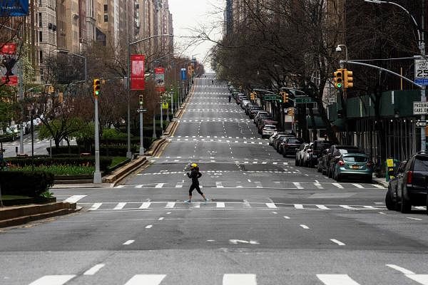 A woman crosses the empty of street Park Avenue in Manhattan as the outbreak of coronavirus disease (COVID-19) continues in New York, U.S. (Credit: Reuters Photo)