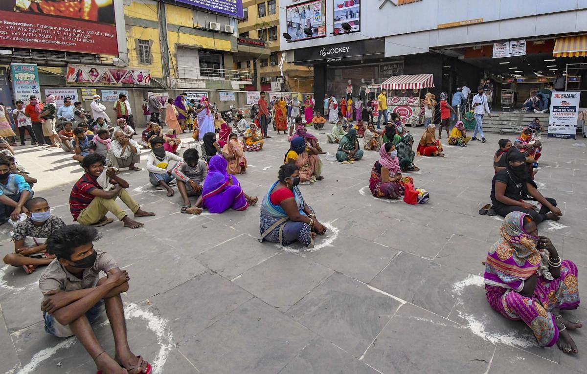  People sit inside marked circles to maintain social distancing, as they wait to collect ration outside a distribution centre during the nationwide lockdown, in wake of coronavirus pandemic, in Patna,Wednesday, April 8, 2020. (PTI Photo)