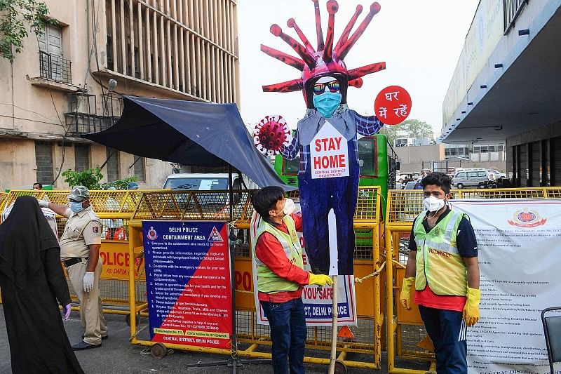  Volunteers raise a cutout of a person in the middle of a road, to create awareness about staying home during the nationwide lockdown imposed to curb the coronavirus pandemic, in New Delhi. (PTI Photo)
