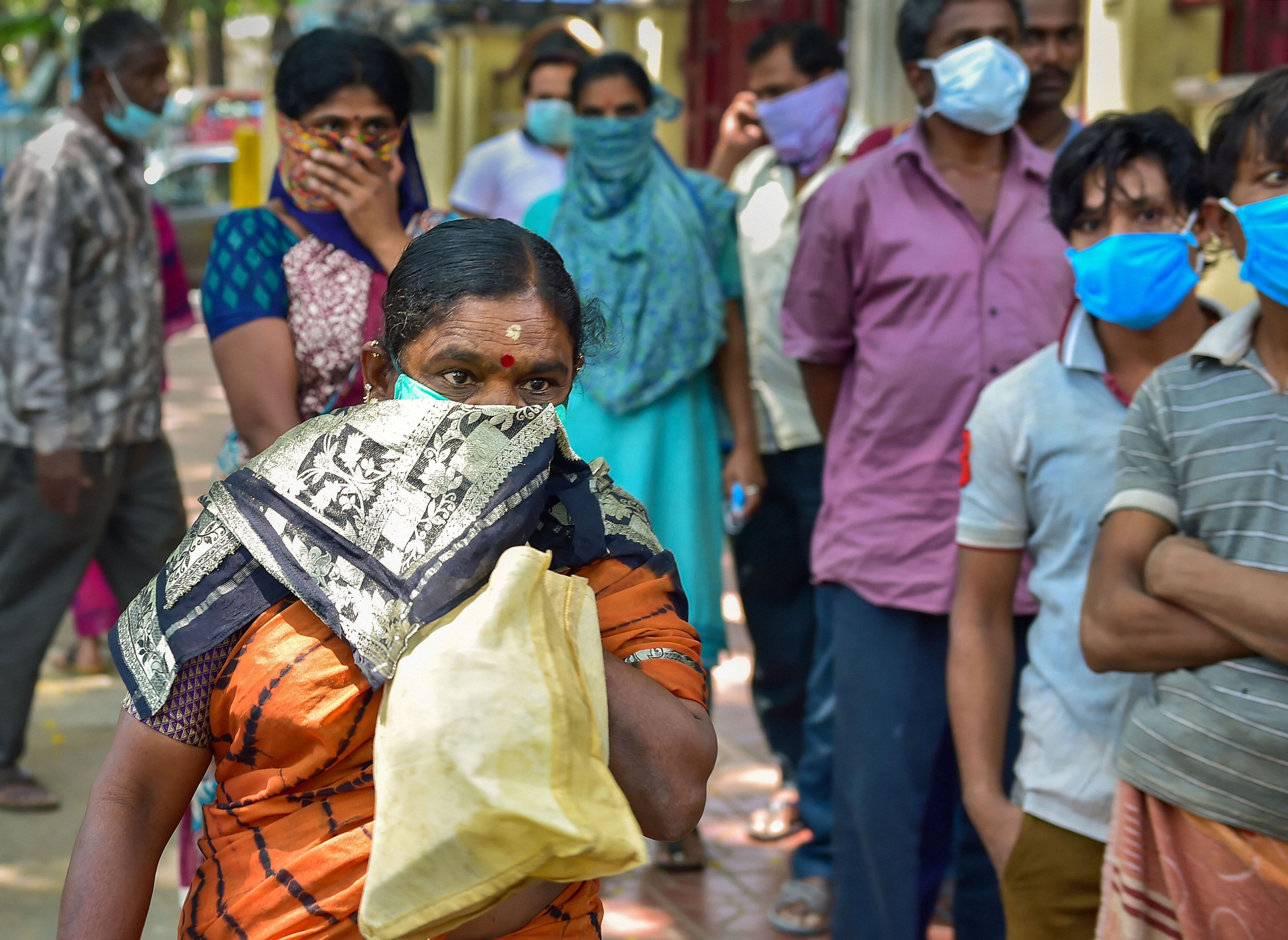 People stand in a queue to receive ration during a nationwide lockdown imposed in the wake of coronavirus pandemic. (PTI Photo)