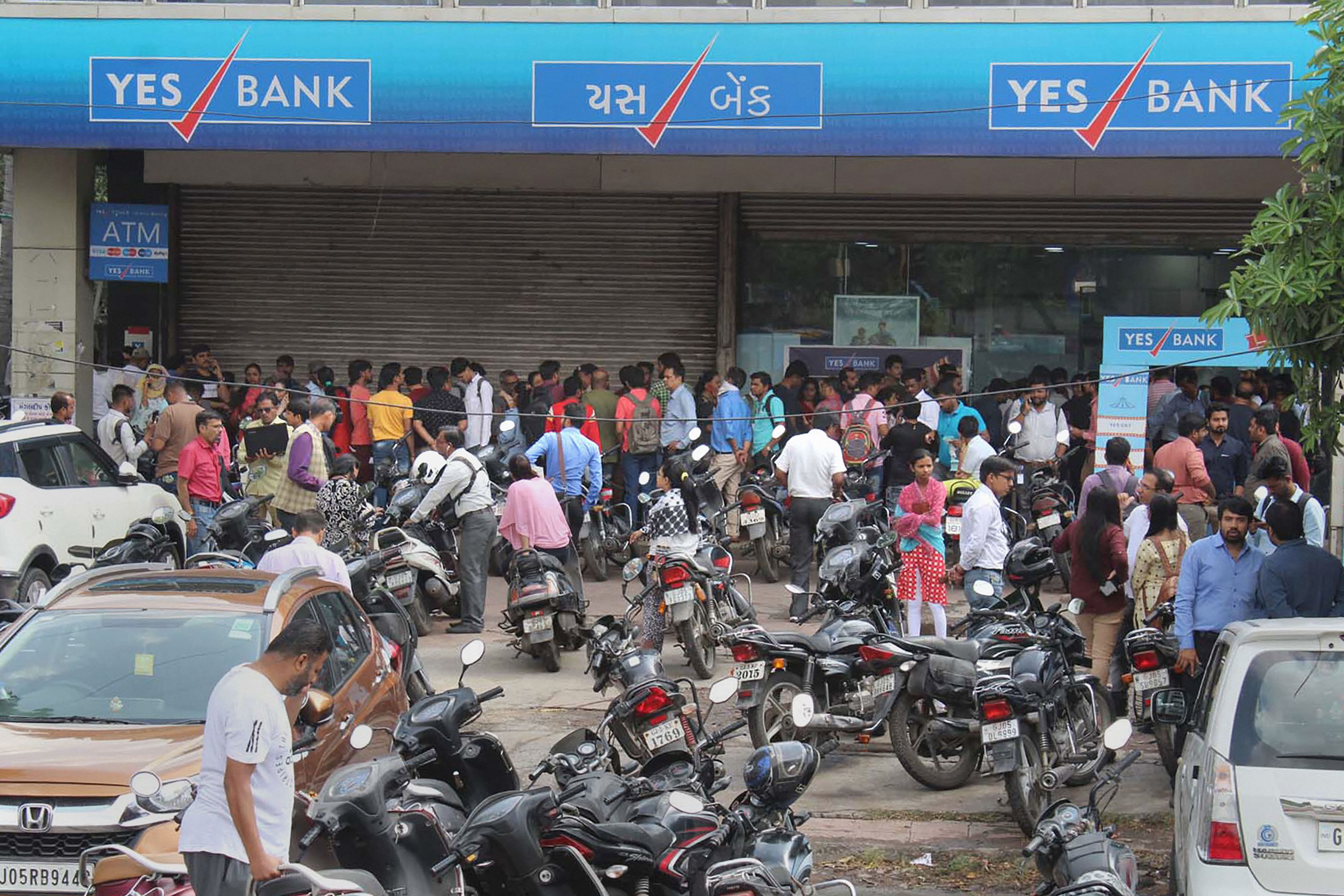  Account holders gather outside Yes Bank to withdraw money, in Surat. (PTI Photo)