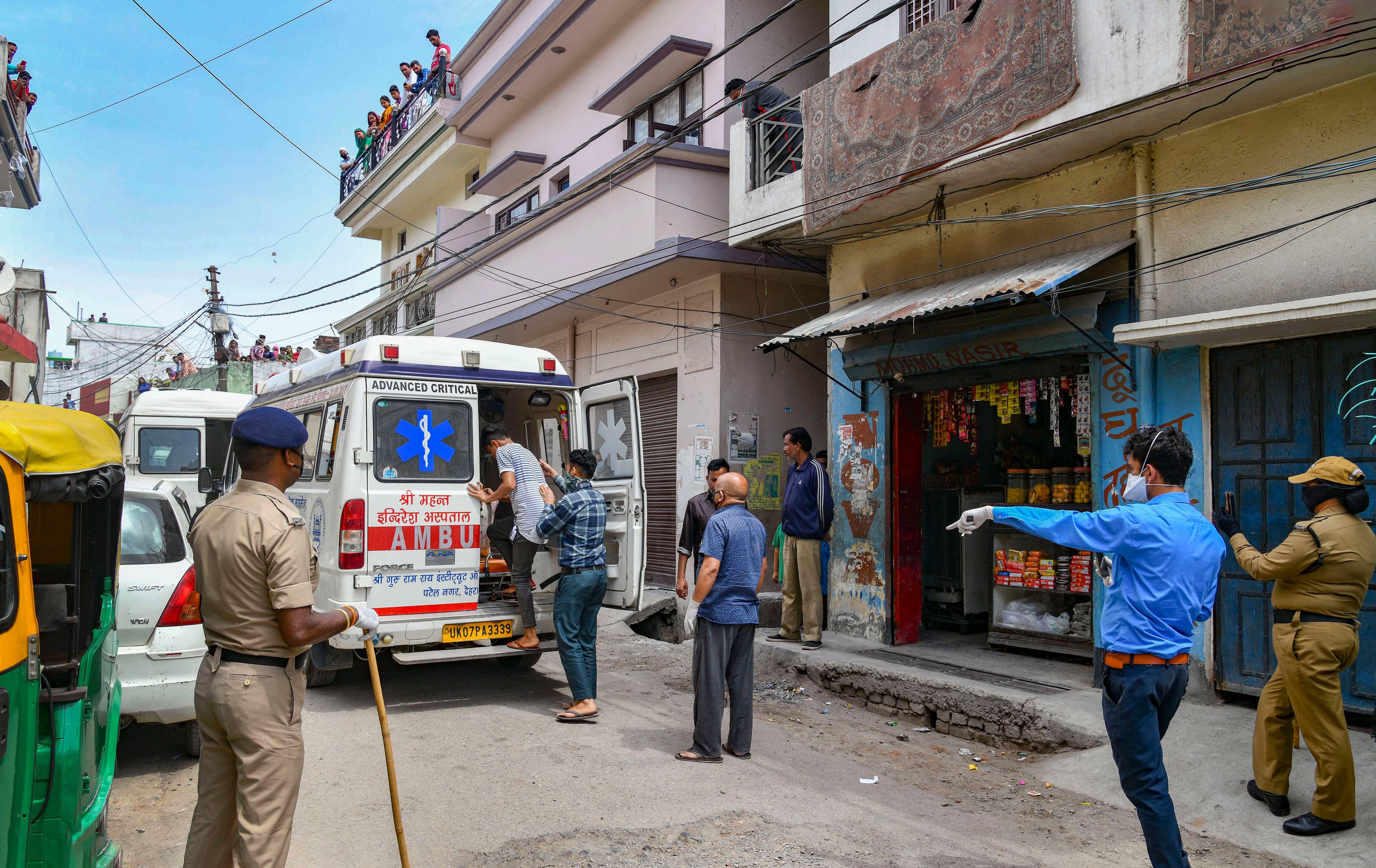 Police and medical workers take family members of a 'muezzin' (who recites prayer-call at mosques) for quarantine after he was detected COVID-19 positive, in Dehradun. (Credit: PTI Photo)