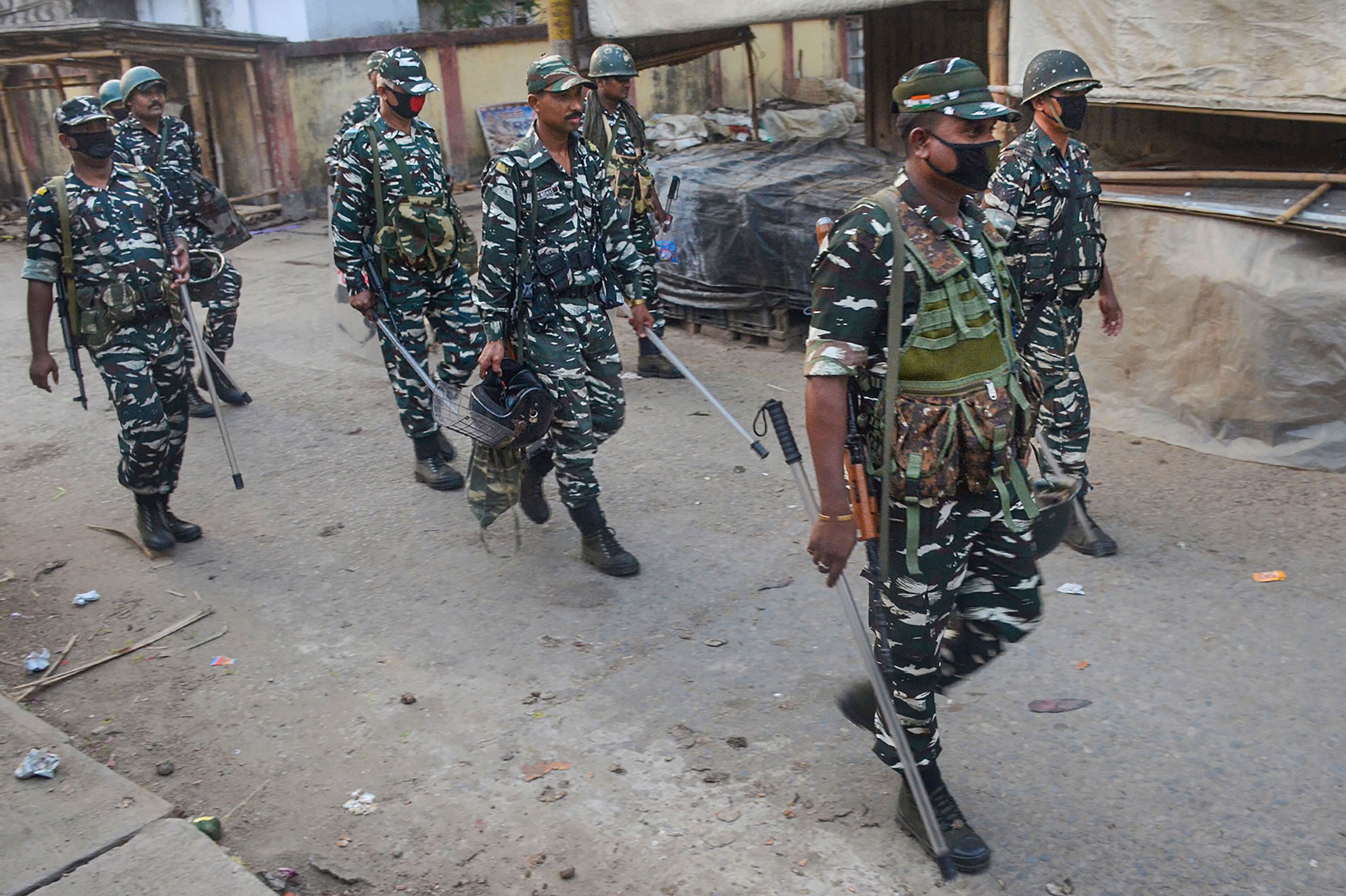 CRPF jawans conduct a flag march at a closed market during the nationwide lockdown in Agartala. (Credit: PTI)