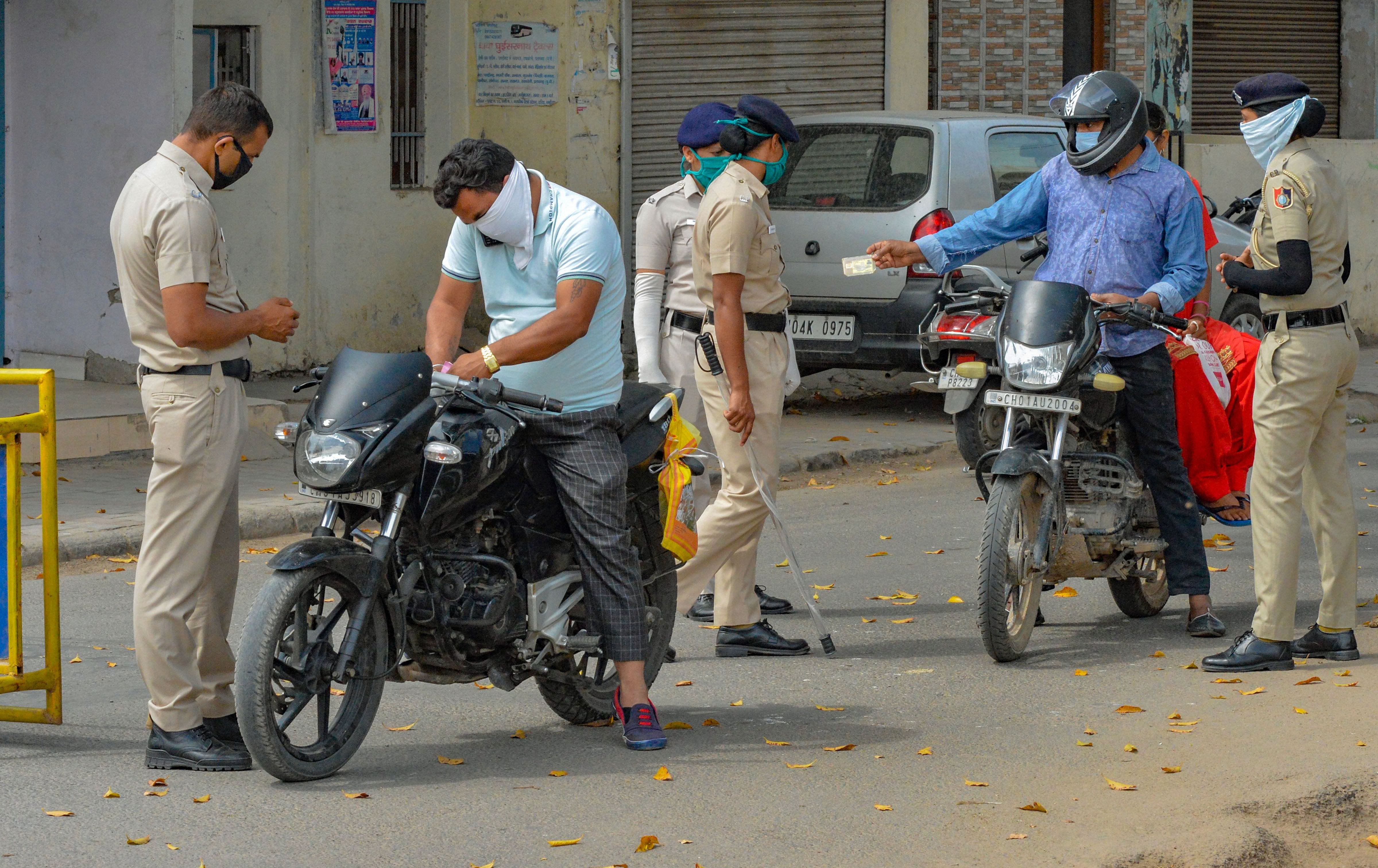 Police check curfew-passes of the commuters during the nationwide lockdown imposed in the wake of coronavirus pandemic. (PTI Photo)