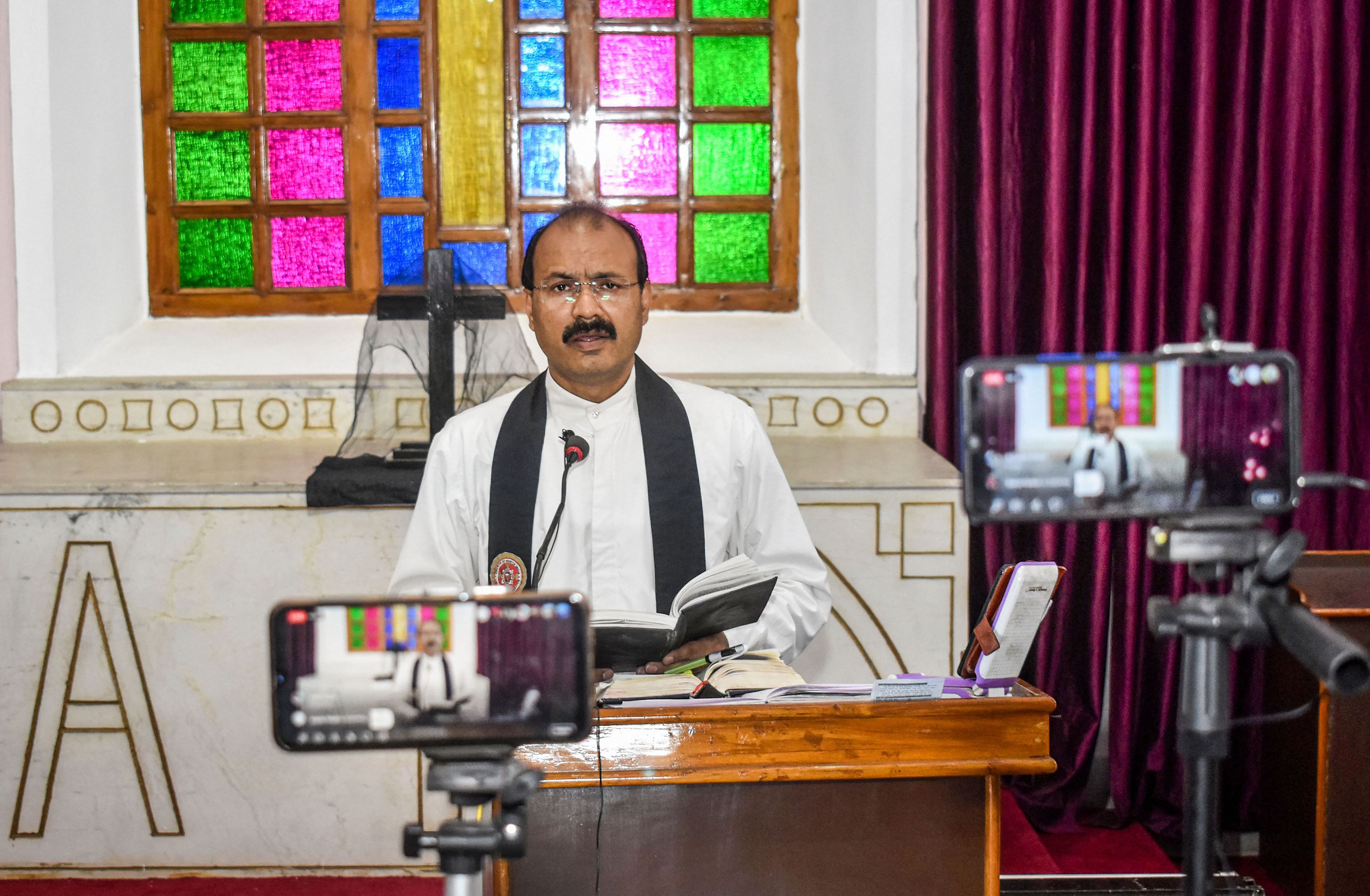 A priest prepares for mass prayers on Good Friday via online live streaming during the nationwide lockdown, in wake of the coronavirus outbreak, at a church, in Prayagraj. (Credit: PTI Photo)