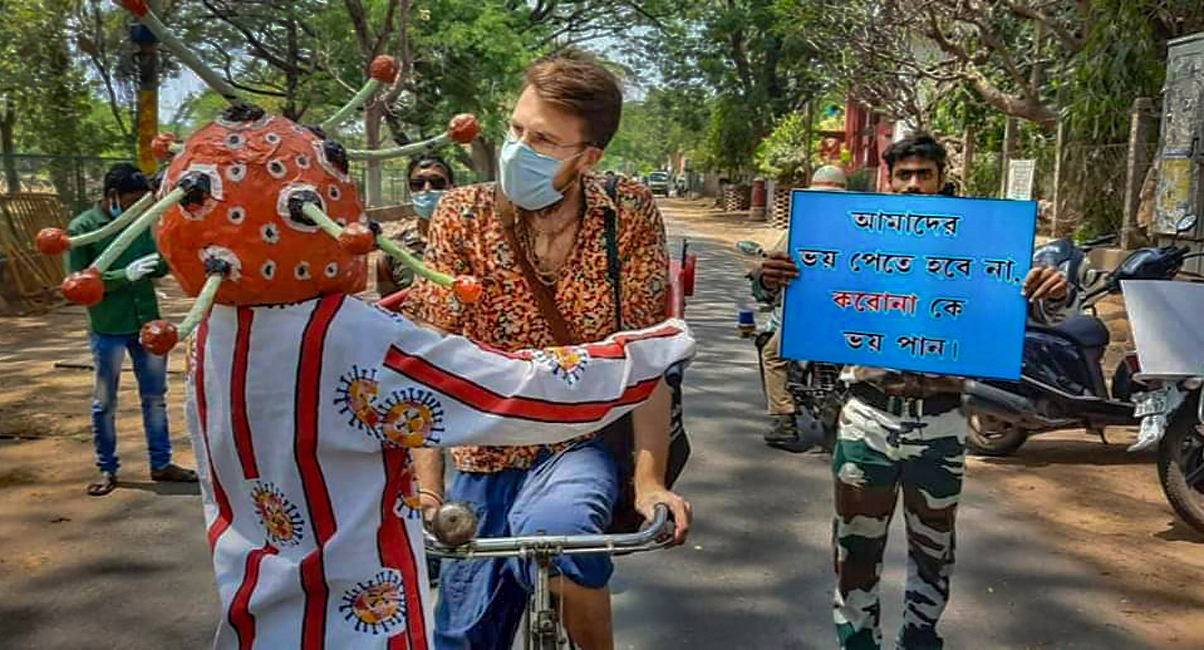 An artist dressed as coronavirus creates awareness about COVID-19 among foreign tourists during a government-imposed nationwide lockdown. (PTI Photo)